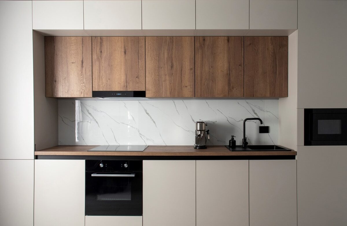 A modern built-in kitchen with appliances in a minimalist style.