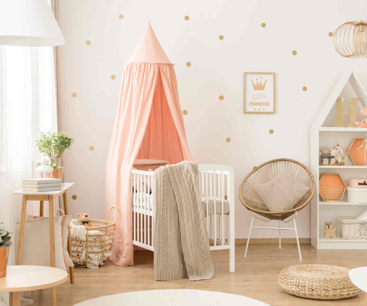 A nursery with a crib, bookshelf, toys, and blankets.