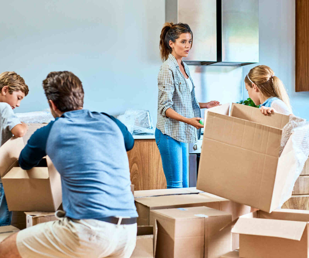 A family of four assembling boxes and packing to move.