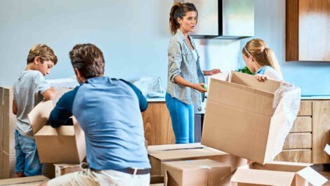 A family of four assembling boxes and packing to move.