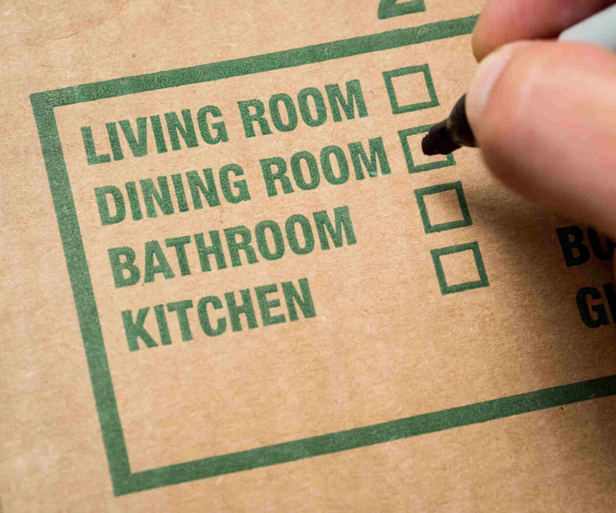 A close-up of a moving box label, with a list of rooms and check-boxes to indicate which room the box corresponds to.