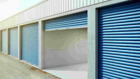 A row of storage units where two are open and you can partially see their contents.